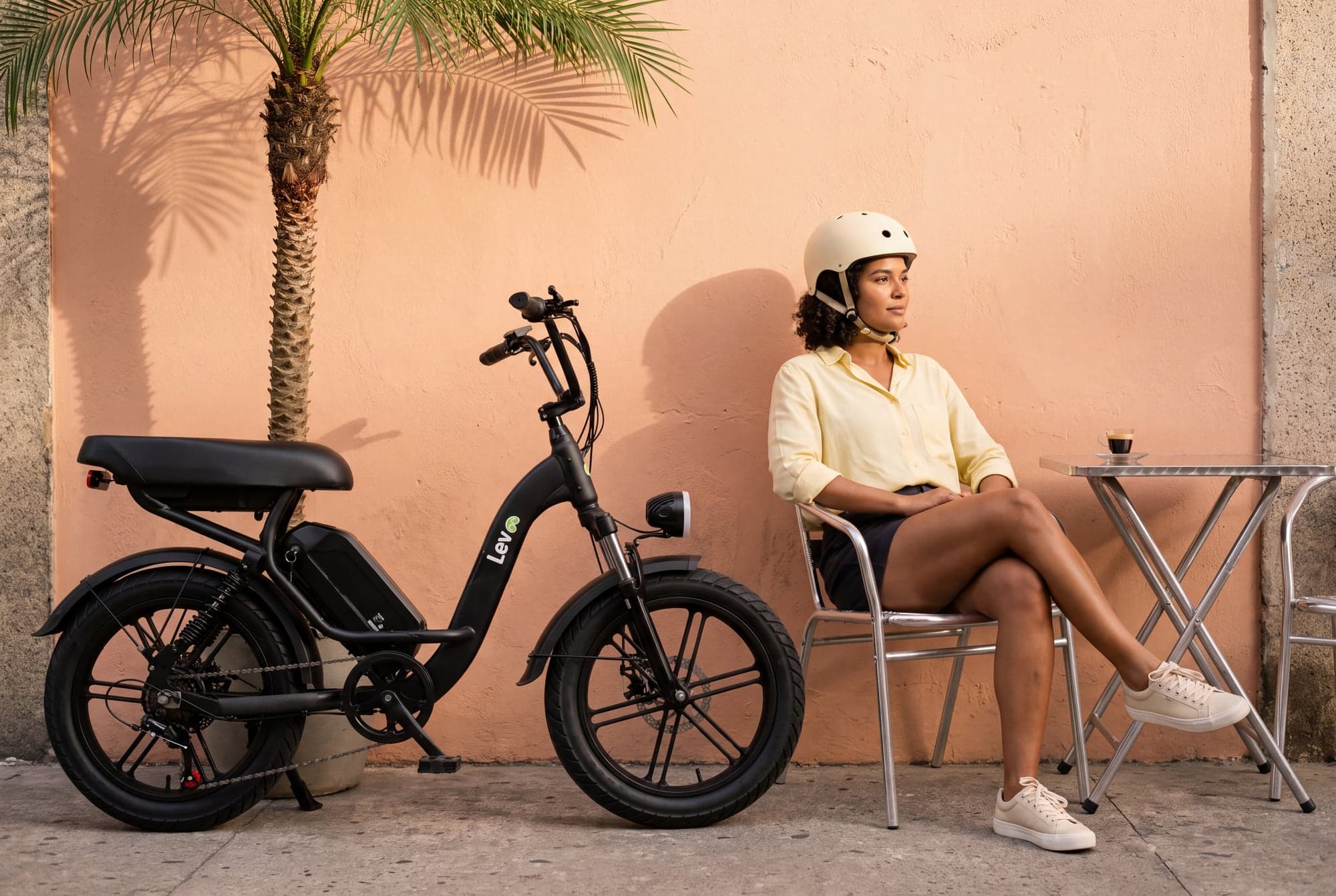 Lev campaign: bicycle and rider against sunlit peach architecture